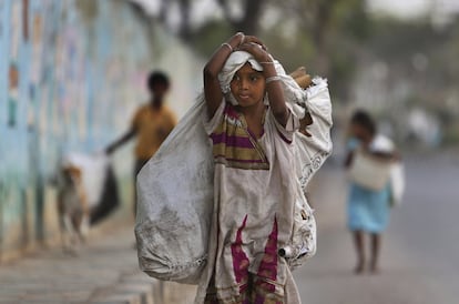 Una niña transporta los objetos reutilizables que ha recogido en la ciudad india de Hyderabad donde el trabajo infantil sigue estando muy extendido a pesar del rápido crecimiento del país.