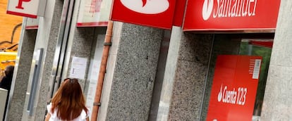 Una mujer paseando por delante de una oficina de Banco Santander y otra del antiguo Banco Popular