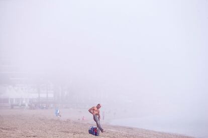 Un hombre en la playa de la Malagueta, en Málaga, que ha amanecido cubierta por una niebla densa llamada "taró", nombre de origen fenicio, producida por los cambios bruscos de temperaturas como los que se han vivido en estos últimos días, en los que se ha pasado del granizo a máximas de 23 grados.