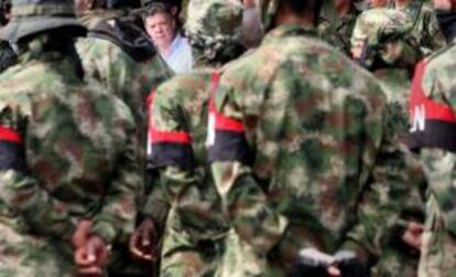 En la imagen, el presidente colombiano, Juan Manuel Santos (atrás), observa a los 30 miembros del Frente de Guerra Suroccidental del ELN desmovilizados en Cali (Colombia). EFE/Archivo