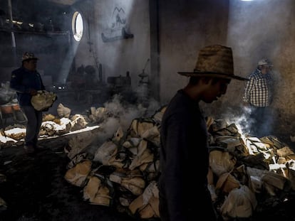 Trabajadores del palenque mezcalero Macurichos trabajan horneando pencas de mezcal en la comunidad de Santiago Matatlán, el pasado 11 de marzo.
