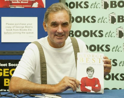 George Best firma copias de sus memorias 'Scoring At Half Time' en Londres en 2003.