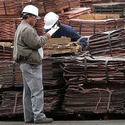 Dos trabajadores inspeccionan planchas de cobre listas para el transporte en Antofagasta.