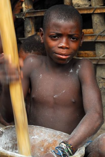 Niño baka haciendo una pasta a base de yuca amarga.