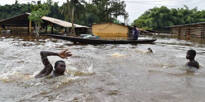 Residentes nadan en un área inundada de Aboisso, Costa de Marfil.