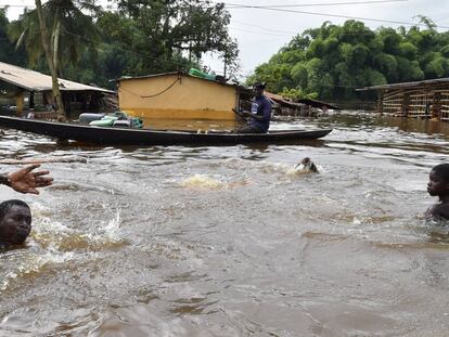 Residentes nadan en un área inundada de Aboisso, Costa de Marfil.