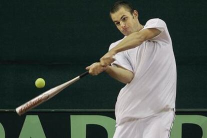 Roddick ensaya con un bate y una pelota de tenis, ayer en el estadio de La Cartuja.