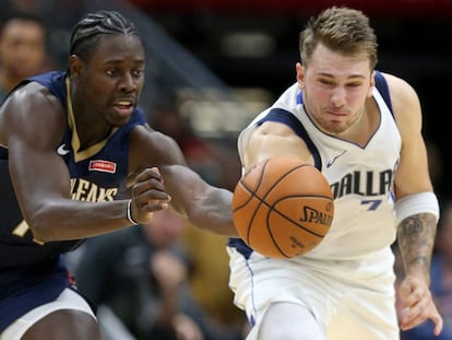 Doncic y Holiday pugnan por un balón. 