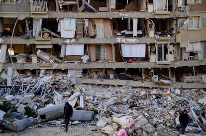 Un hombre anda con muletas frente a los escombros de un edificio en la región turca de Hatai, este viernes. 