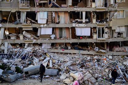 Un hombre anda con muletas frente a los escombros de un edificio en la región turca de Hatai, este viernes. 