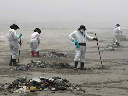 Personal limpia y recoge basura en la playa Cavero en el distrito de Ventanilla en Lima (Perú).