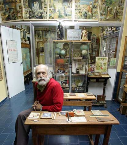 Pizarra y libros de la colección Molero. 

Antonio Molero se sienta en uno de los antiguos pupitres, en su museo.