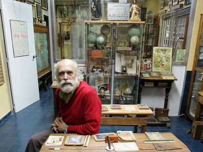 Pizarra y libros de la colección Molero. 

Antonio Molero se sienta en uno de los antiguos pupitres, en su museo.