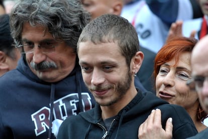 La madre de Simoncelli abraza a Valentino Rossi, mientras abandonan, junto al padre de Sic, la iglesia donde se celebró el funeral.