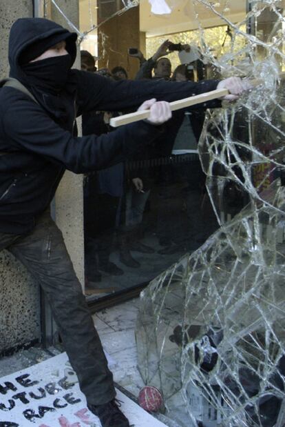 Un manifestante destroza uno de los ventanales de la Whitehall Tower, sede de los conservadores.
