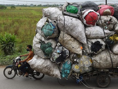 Una persona transporta residuos de plástico para su reciclaje en los suburbios de Hanoi (Vietnam).