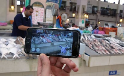 Un jugador usa su Pokémon Go en el mercado principal de pescado de Kuwait.