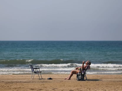 Una dona pren el sol a la platja de Salou.