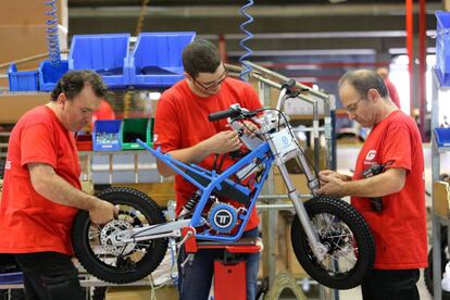 Operaris de la fàbrica de Torrot a Salt assemblen una moto.