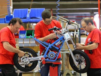 Operaris de la fàbrica de Torrot a Salt assemblen una moto.