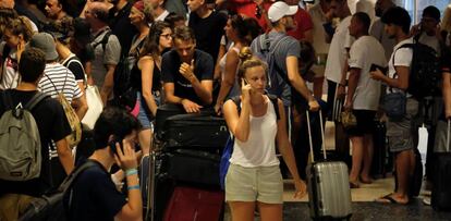 Pasajeros de Ryanair hacen cola en el aeropuerto de Valencia, frente a un puesto de información, durante la huelga de trabajadores de la compañía.