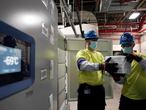 The temperature on a freezer reads -69 degrees Celsius as workers move boxes containing the Pfizer-BioNTech COVID-19 vaccine to be shipped at the Pfizer Global Supply Kalamazoo manufacturing plant in Portage, Mich., Sunday, Dec. 13, 2020. (AP Photo/Morry Gash, Pool)