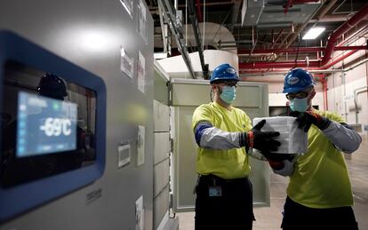 Workers moving boxes containing Pfizer’s coronavirus vaccine.