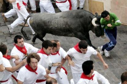 Los toros de la ganadería cacereña de Victorino Martín han protagonizado el octavo y último de los encierros de los Sanfermines 2006 con una veloz carrera en la que se registraron varios golpes y caídas pero en la que al parecer no hubo empitonados, aunque sí algún varetazo. La imagen corresponde al tramo de Mercaderes en donde uno de los Victorinos empujó con la testuz a un mozo golpeandole contra el vallado.