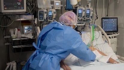 Un sanitario atiende a un enfermo ingresado en el Hospital Clínic de Barcelona.