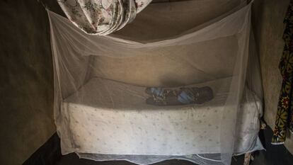 Una niña se echa la siesta bajo una mosquitera tratada con insecticida. Uganda, diciembre 2018.