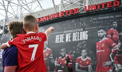 Un padre y su hjjo, con la camiseta de Cristiano frente a la fachada de Old Trafford.