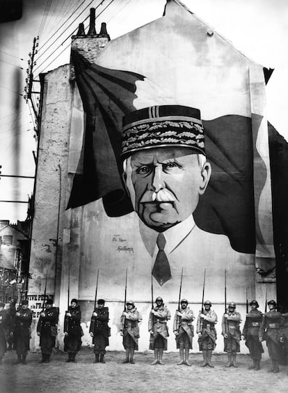 Una parada militar delante de un mural con el retrato del mariscal Pétain en Vichy durante la Segunda Guerra Mundial.