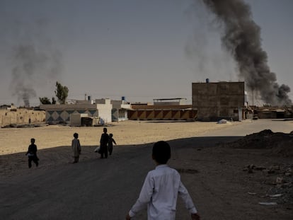 Varios niños observan el humo que se levanta tras los esfuerzos del Ejército afgano y la policía por frenar el avance de los talibanes, el 12 de agosto.