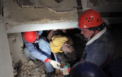 Miembros de un equipo de rescate ruso sacan a una joven que había quedado atrapada entre los escombros de su casa, en la route Delmas de Puerto Príncipe (16/01/2010)