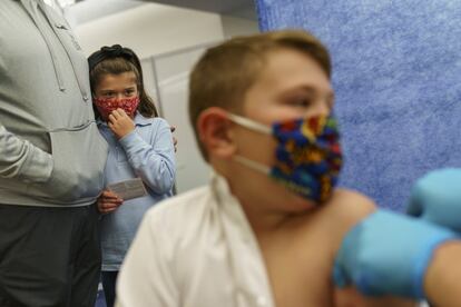 Dos niños, de 8 y 10 años, reciben la vacuna de Pfizer contra la covid-19 para niños de 5 a 11 años en un sitio estatal en Cranston, Rhode Island, EE UU.