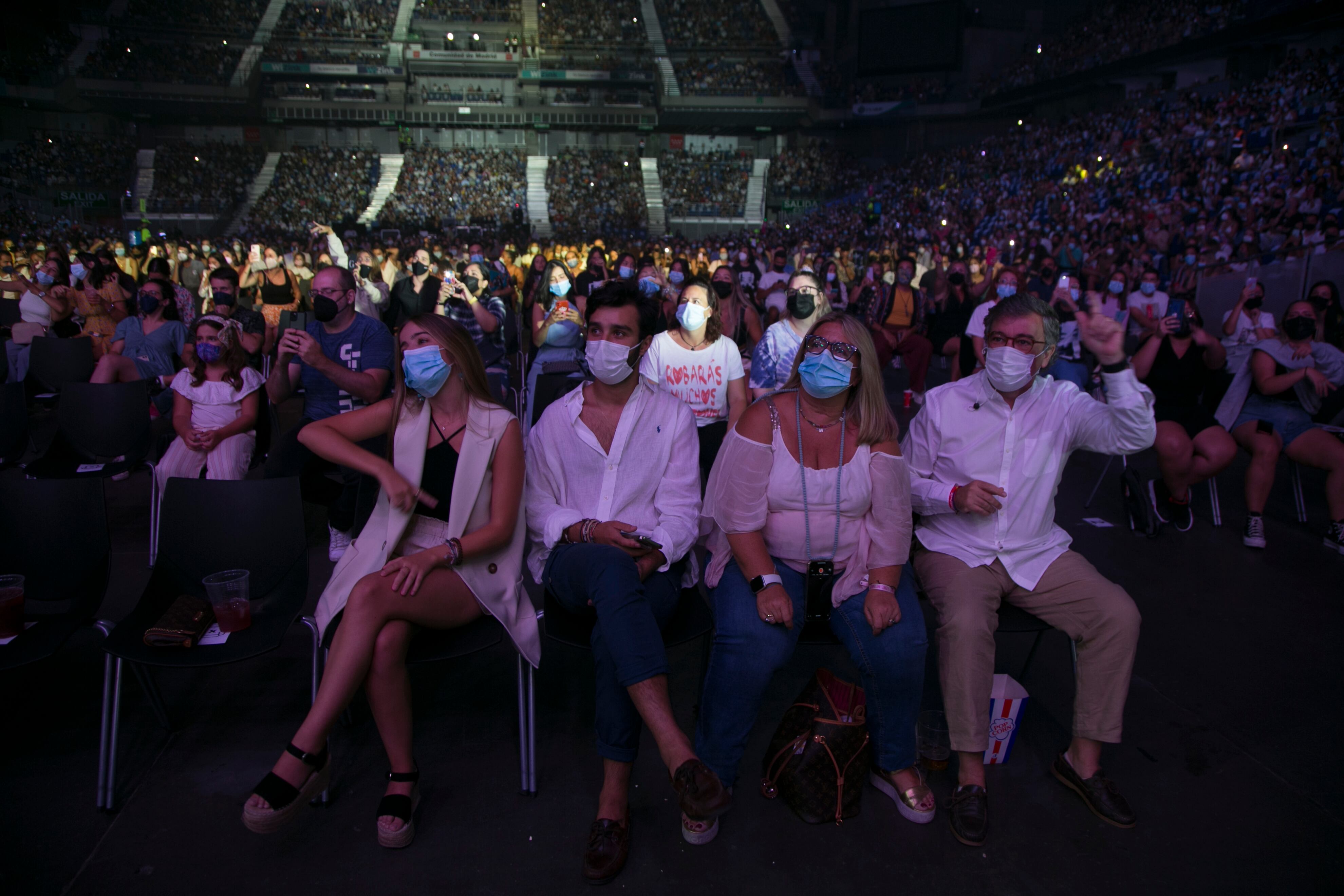 Una familia disfruta del concierto de Camilo en Madrid, en el WiZink Center.