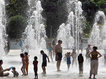 Gente refrescándose en una fuente del parque André Citroën, en París.