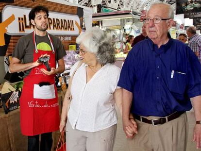 Dos vecinos pasan junto al &#039;puesto&#039; de venta de armas en Valencia.