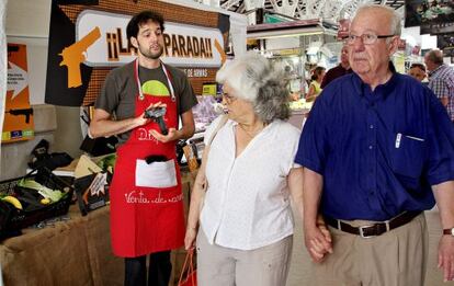 Dos vecinos pasan junto al &#039;puesto&#039; de venta de armas en Valencia.