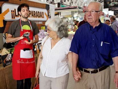 Dos vecinos pasan junto al 'puesto' de venta de armas en Valencia.