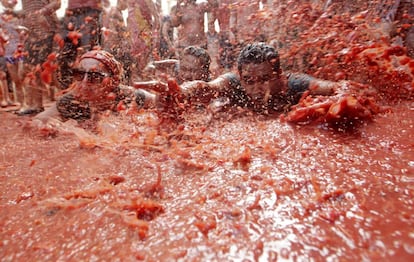 Personas tumbadas en el suelo durante la tradicional batalla con tomates.