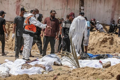 Varios sanitarios exhuman cadáveres en una fosa común, el lunes en el recinto del hospital Nasser de Jan Yunis (Gaza).