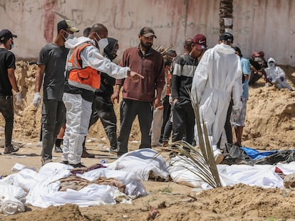 Varios sanitarios exhuman cadáveres en una fosa común, el lunes en el recinto del hospital Nasser de Jan Yunis (Gaza).