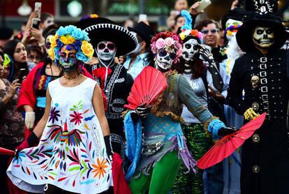 "Los mexicanos celebramos la muerte en vez de temerle. ¿Para qué? Para alargar la vida y la fiesta hasta el más allá. Es nuestra forma de alcanzar la eternidad, la inmortalidad", contó Rodolfo Arteaga, un profesor de Geografía que acudió disfrazado de calavera rockera junto a su esposa, sus dos hijos y su perro. En la imagen, un grupo de personas posa durante el desfile en Ciudad de México.