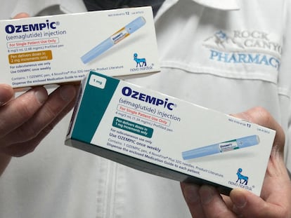 A pharmacist displays boxes of Ozempic.