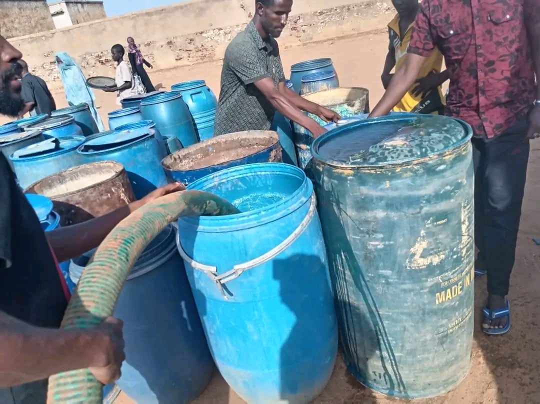 Grupos de voluntarios repartiendo agua, suministrada por un camión cisterna, en El Obeid, Kordofán del Norte, Sudán, en junio de 2026.