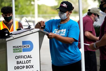 Una mujer sella uno de los buzones para depositar el voto por adelantado en el condado de Miami-Dade