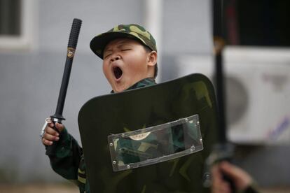 Un niño bosteza durante un entrenamiento en el campamento militar de verano.