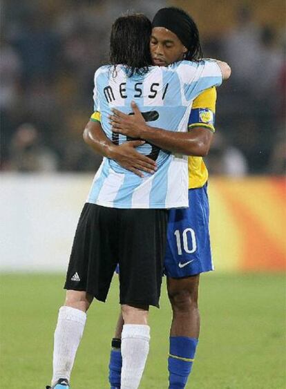 Messi y Ronaldinho, que fueron compañeros en el Barcelona, se abrazan al término del partido.