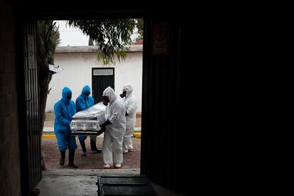 Trabajadores de un crematorio cargan un ataúd en el municipio de Ecatepec, en el Estado de México.